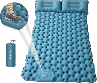 A blue inflatable camping mattress with two built-in pillows, shown with a close-up of a foot stepping on it and a rolled-up mattress in a carrying bag.