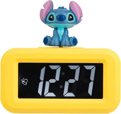 A yellow digital alarm clock with a Stitch figurine on top.