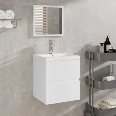 A white bathroom vanity with a sink and mirror, mounted on a tiled wall.