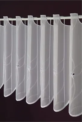 A close-up view of several white sheer curtains hanging on a rod.