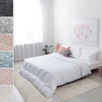 A bedroom scene with a bed and rugs.