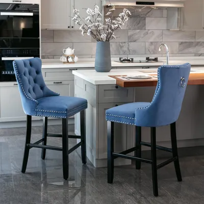 Two blue velvet bar stools in a modern kitchen setting.