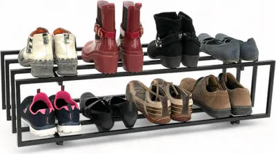 A two-tier black metal shoe rack filled with various shoes.