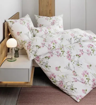A close-up view of a bed with floral patterned bedding.
