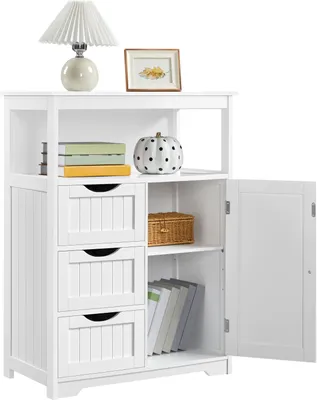 A white wooden cabinet with three drawers and an open door, displaying books, a decorative pumpkin, and a woven basket.