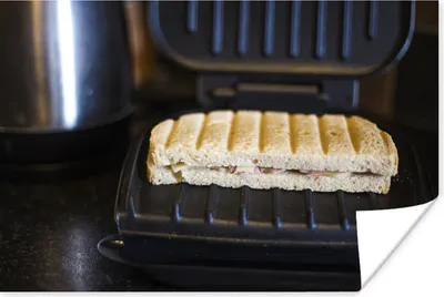 Produktbild von MuchoWow® Poster Toast auf einem schwarzen Sandwicheisen 120x80 cm - Bilder