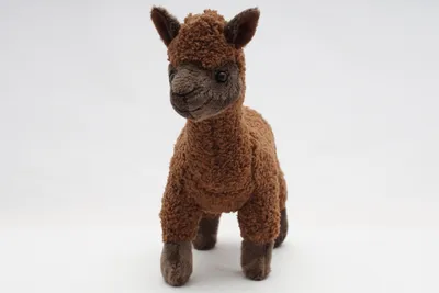 A brown plush toy llama or alpaca stands on a white background.