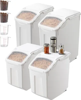 A set of white food storage containers with clear lids, some filled with pasta, and small spice grinders and shakers on top of one container.