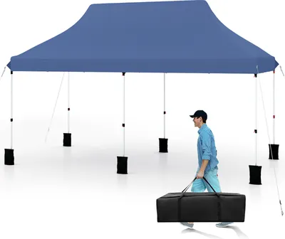 A man walks past a blue pop-up canopy tent, carrying a black carrying bag.