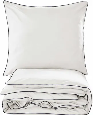 A neatly folded set of white bedding with navy trim, including a pillow and a duvet or comforter.