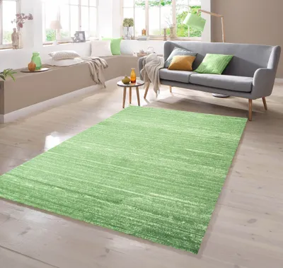 A living room setting with a sofa, rug, and seating area.