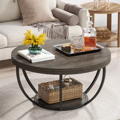 A round coffee table with items on it, placed in a living room setting.