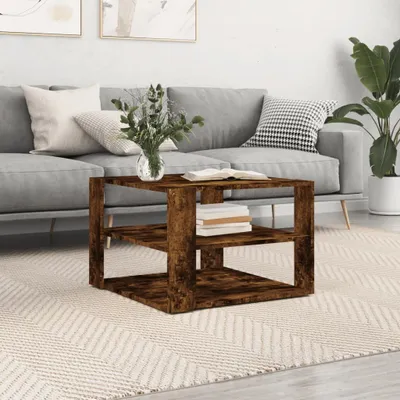 A wooden coffee table with books and a vase of flowers is placed in front of a sofa in a living room.