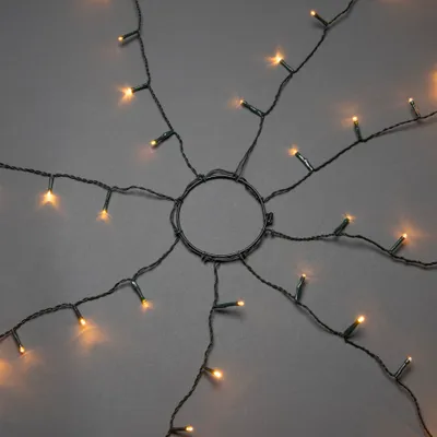 Produktbild von Konstsmide LED Baummantel mit Ring, 8 Stränge à 30 Dioden, vormontiert, mit Glimmereffekt, 240 bernsteinfarbene Dioden (120 glimmend), 24V Innentrafo, dunkelgrünes Kabel - 6365-810