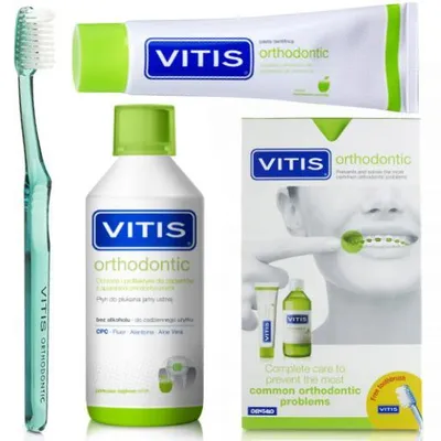 A flat lay of VITIS orthodontic dental care products including a toothbrush, toothpaste, and mouthwash, along with their packaging.