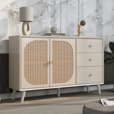 A beige sideboard with cane detailing and gold hardware, set against a marble-patterned wall.