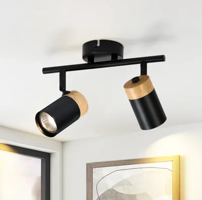 A black and wood track light fixture mounted on a white ceiling.