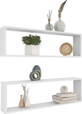 Two white cube shelves are displayed against a white background, each adorned with various decorative items.