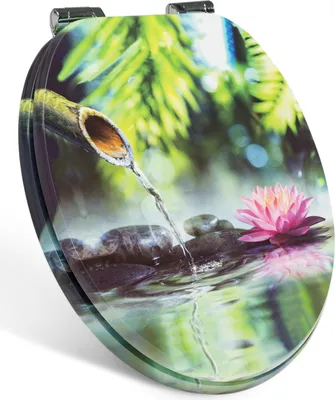 A toilet seat with a nature-themed design featuring a bamboo fountain, water, stones, and a lotus flower.
