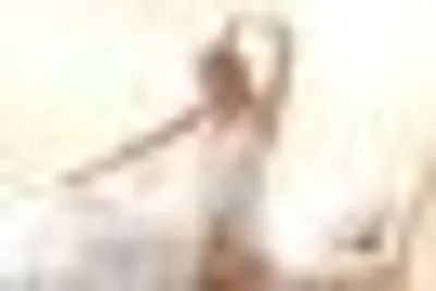 A blurred person posing in front of a light background.