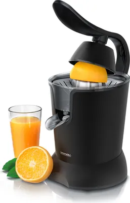 A black electric citrus juicer with a half-orange and a glass of orange juice beside it, against a white background.
