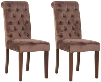 Two brown velvet dining chairs with tufted backs and wooden legs are shown against a white background.