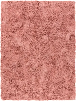A close-up, top-down view of a pink shag rug.