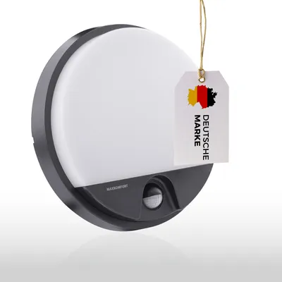 A round, black and gray outdoor LED wall light with a motion sensor is shown against a white and light gray background. A tag with the German flag and the text 'DEUTSCHE MARKE' is attached to the light.