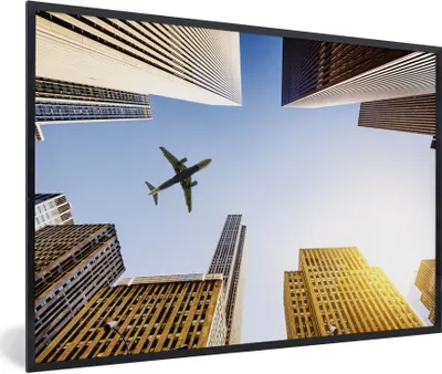 Produktbild von MuchoWow® Gerahmtes Poster Flugzeug zwischen den Wolkenkratzern 30x20 cm - Poster mit Schwarzem Bilderrahmen Wandposter Rahmen Foto Bilder - Kunstdruck - Bild-Poster