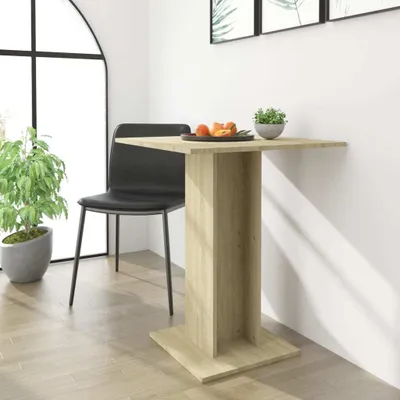 A small square bistrot table with a wooden finish, a black chair, and a potted plant next to a large arched window.