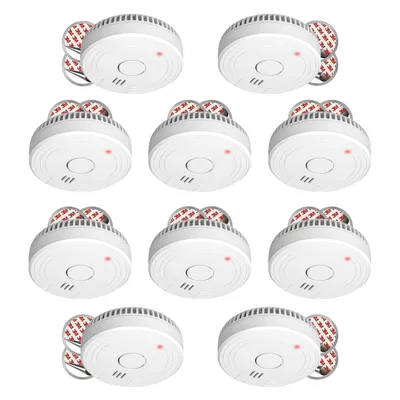 A top-down view of a collection of smoke detectors arranged in rows on a white background.