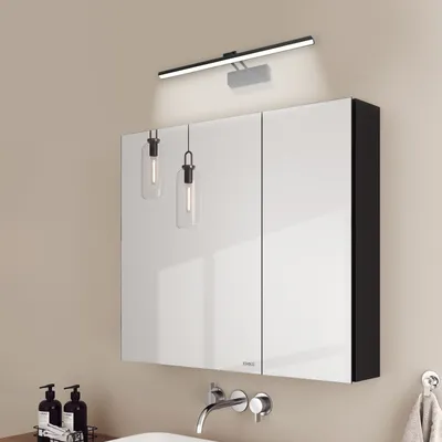 A bathroom vanity with a mirrored cabinet and wall-mounted lights.