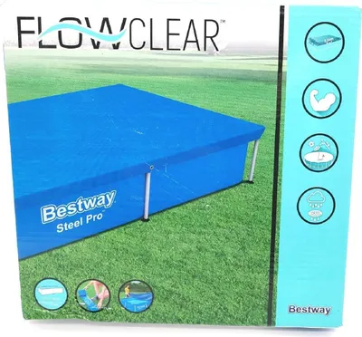 The image shows the packaging of a rectangular pool cover on a grassy surface.