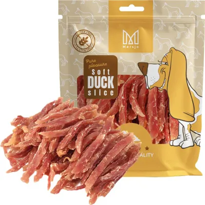 A bag of dog treats with some treats spilled out in front of it.