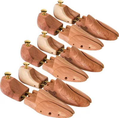 A collection of wooden shoe trees arranged in a diagonal pattern against a white background.