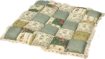 A patchwork seat cushion with floral and gingham patterns, trimmed with lace.