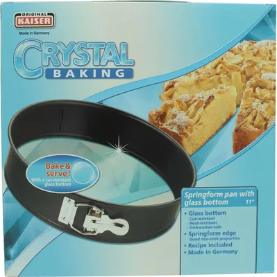 The image shows the packaging of a Kaiser Crystal Baking springform pan, featuring a picture of the pan and a slice of apple cake.