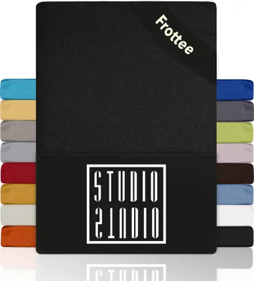 A black fitted sheet is shown with a stack of other colored fitted sheets on the left and right sides. The brand logo is visible on the front of the sheet.