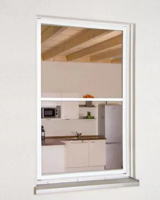 A kitchen interior seen through a window with a screen.