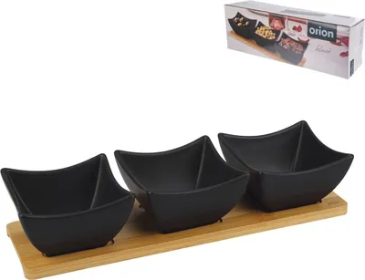 A set of three black serving bowls on a wooden tray, with a product box in the background.