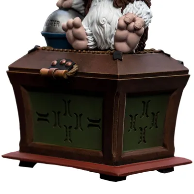 A close-up view of a decorative box with a character's feet resting on top.