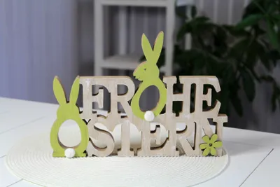 Produktbild von Deko-Schriftzug FROHE OSTERN mit weißen Puscheln, zum Stellen oder Aufhängen, ca. 29 x 3,5 x 20,5 cm, naturfarben/grün
