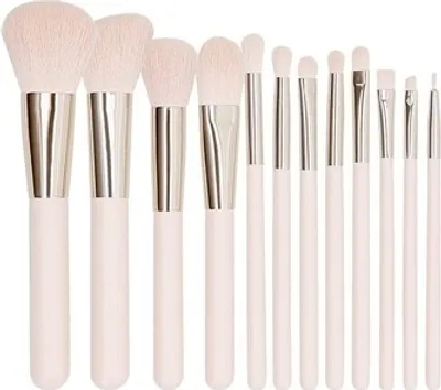 A set of 12 makeup brushes with pink handles and silver ferrules, arranged in a row against a white background.