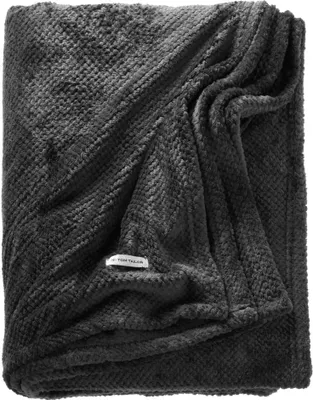 A folded dark gray blanket with a textured pattern and a small white tag.
