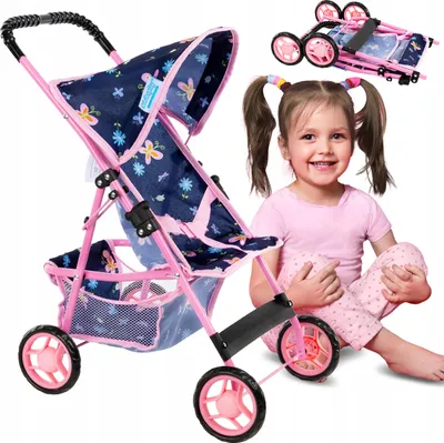 A young girl is sitting on the floor next to a doll stroller. The stroller is pink and navy blue with a butterfly pattern. The girl is smiling and looking at the camera.