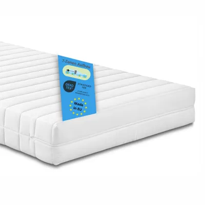 A white mattress with a blue tag attached to it, shown from a diagonal angle against a white background.