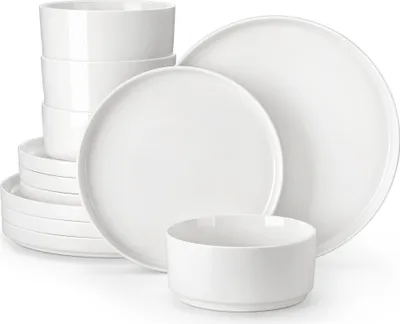 A stack of white ceramic bowls and plates arranged on a white background.