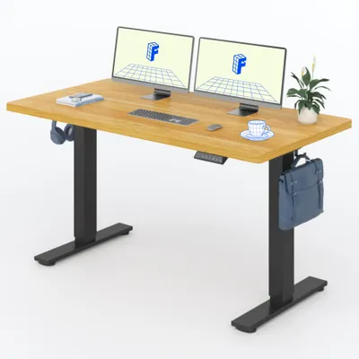 A wooden standing desk with two monitors, a keyboard, a mouse, a cup of coffee, headphones, and a bag hanging from the side.