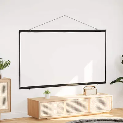 A white projection screen is hanging on a white wall above a wooden cabinet. A small plant is on the cabinet.