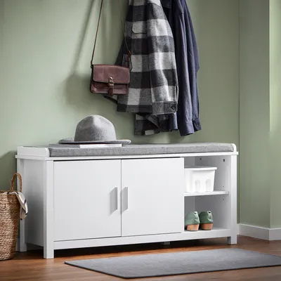 An entryway scene with a shoe bench, coats, and accessories.